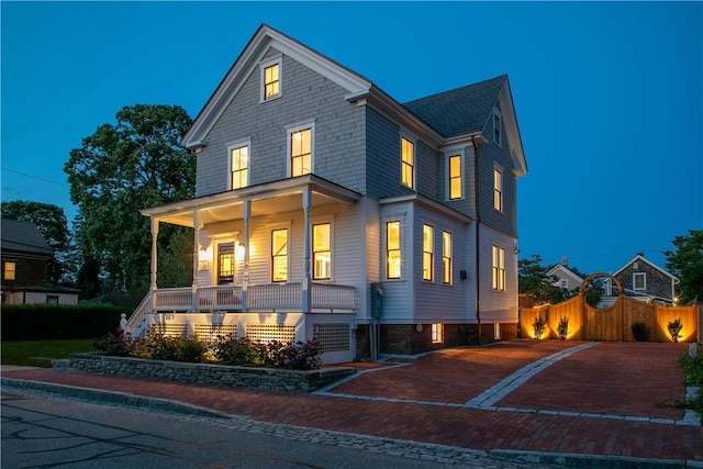 view of front of home with covered porch and fence