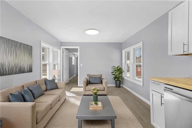 living area with light wood-type flooring and baseboards