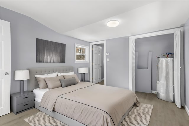 bedroom featuring lofted ceiling and light wood-type flooring