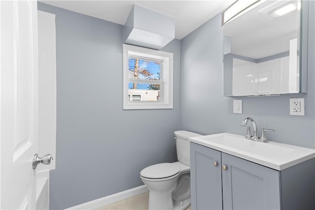 full bath featuring toilet, vanity, and baseboards