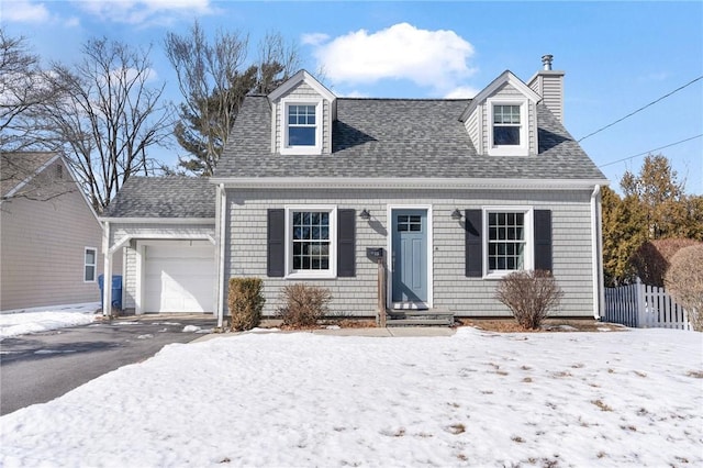 cape cod home with aphalt driveway, roof with shingles, a chimney, an attached garage, and fence