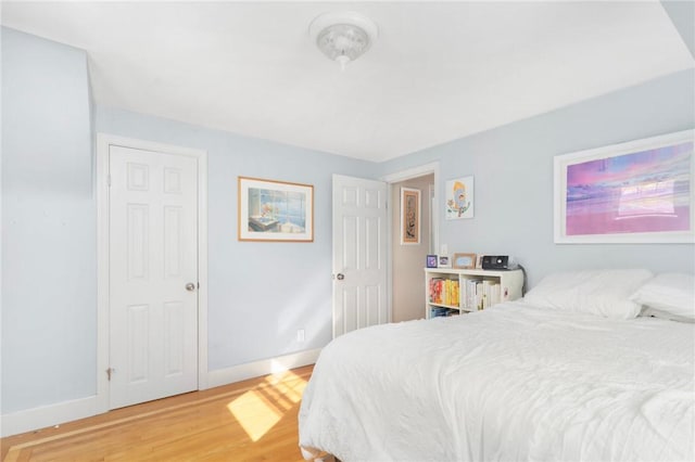 bedroom featuring baseboards and wood finished floors