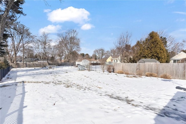 yard covered in snow featuring fence