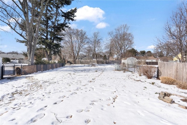 yard layered in snow featuring fence