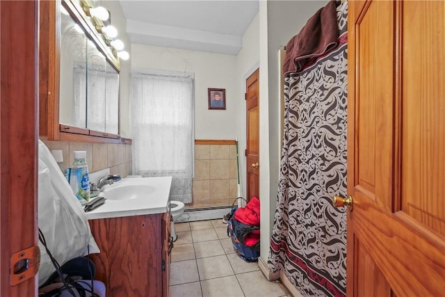 full bathroom with toilet, tile patterned floors, baseboard heating, vanity, and tile walls