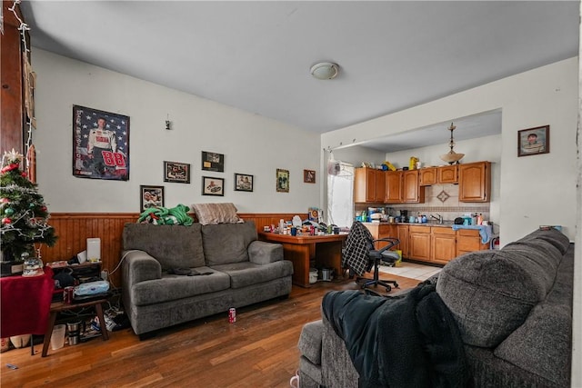 living area with light wood-type flooring, a wainscoted wall, and wooden walls