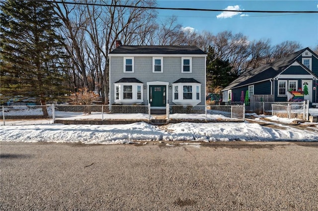 view of front facade with a fenced front yard and a chimney