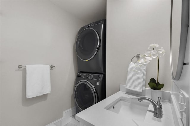 bathroom with baseboards, stacked washer / drying machine, and vanity