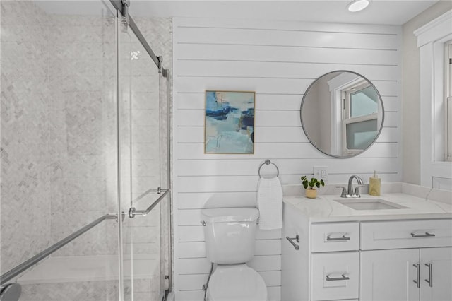 full bath with wooden walls, vanity, toilet, and a shower stall