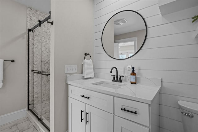 bathroom featuring marble finish floor, visible vents, vanity, a shower stall, and baseboards