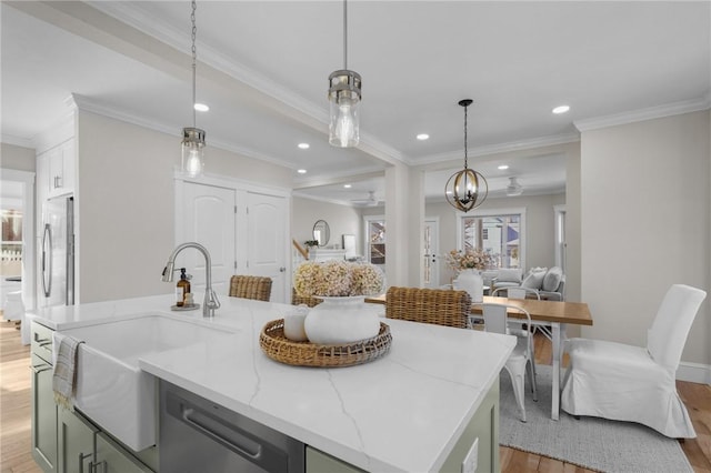 kitchen featuring hanging light fixtures, a kitchen island with sink, open floor plan, and a sink