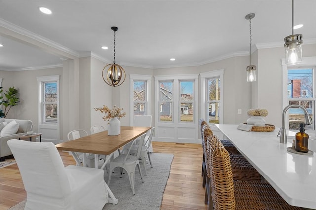 dining space featuring light wood-style floors, a notable chandelier, crown molding, and recessed lighting