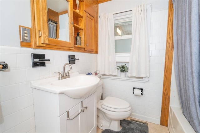 bathroom featuring visible vents, toilet, shower / bath combination with curtain, vanity, and tile walls