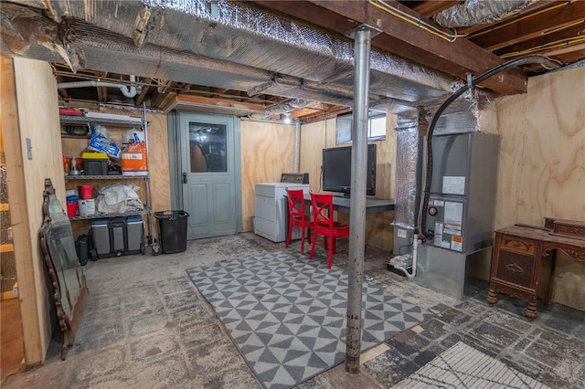 unfinished basement featuring washer / dryer and heating unit