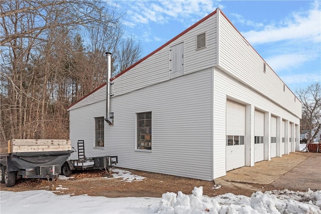 view of snowy exterior with a garage