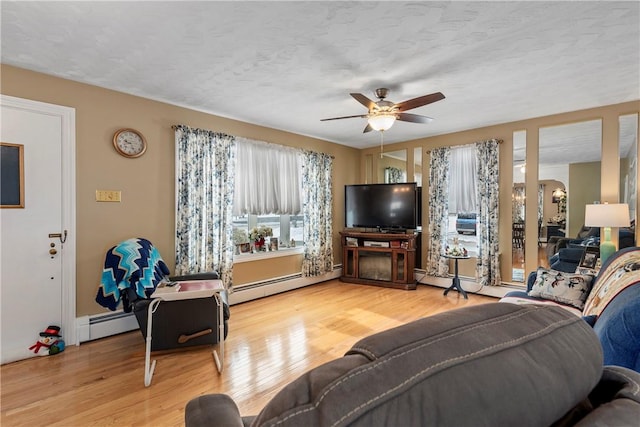 living area featuring light wood-type flooring, a baseboard radiator, a textured ceiling, and a ceiling fan