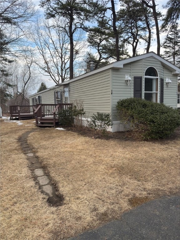 view of side of home featuring a deck and a yard