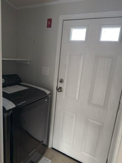 clothes washing area with ornamental molding, laundry area, a healthy amount of sunlight, and wood finished floors