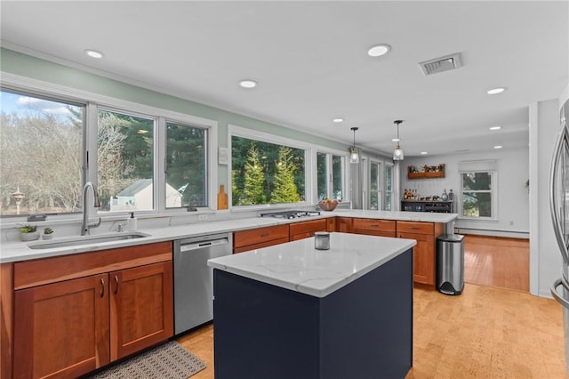 kitchen featuring a wealth of natural light, visible vents, appliances with stainless steel finishes, a sink, and a peninsula