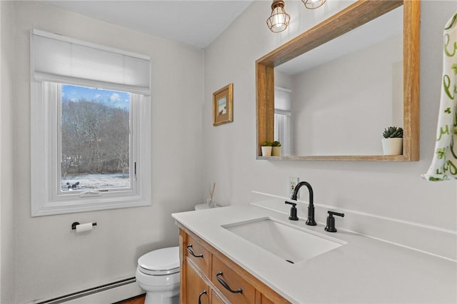 half bathroom with a baseboard heating unit, vanity, and toilet