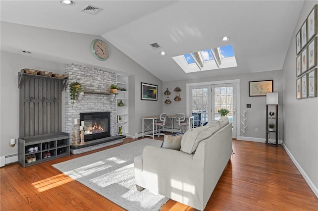 living room with lofted ceiling, wood finished floors, visible vents, and built in features