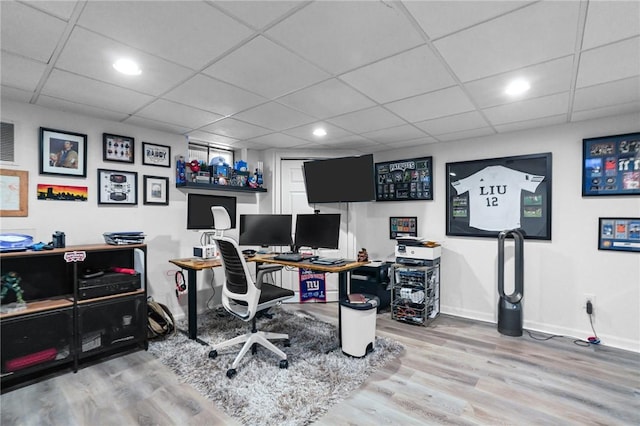 office area featuring a drop ceiling, wood finished floors, and baseboards