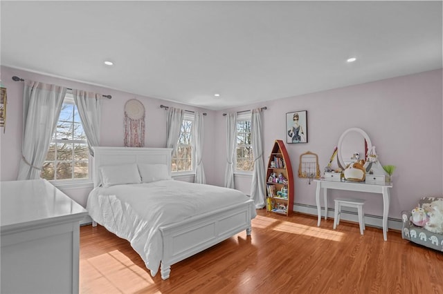 bedroom featuring light wood-type flooring, a baseboard radiator, and recessed lighting