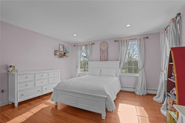 bedroom featuring baseboards, a baseboard radiator, wood finished floors, and recessed lighting