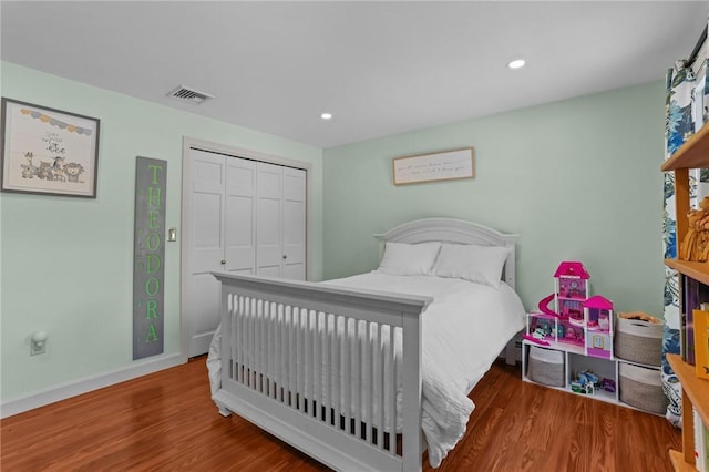 bedroom featuring recessed lighting, a closet, visible vents, and wood finished floors