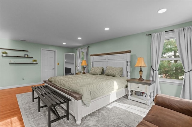 bedroom with recessed lighting, visible vents, baseboards, and wood finished floors