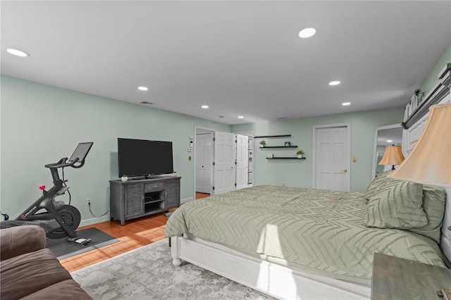 bedroom with baseboards, wood finished floors, and recessed lighting