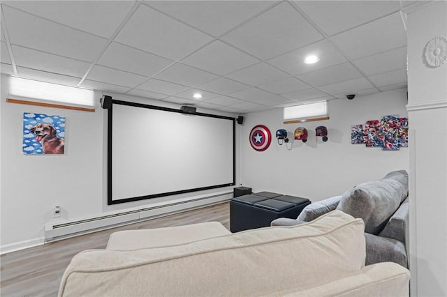 home theater room featuring a baseboard heating unit, wood finished floors, a paneled ceiling, and recessed lighting