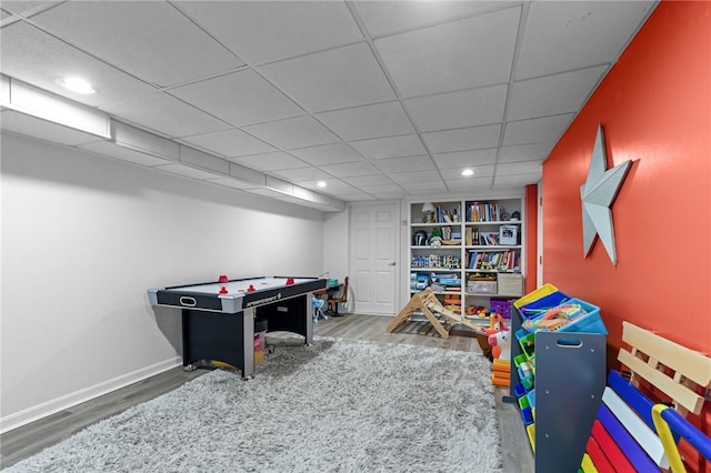 rec room with a paneled ceiling, recessed lighting, baseboards, and wood finished floors