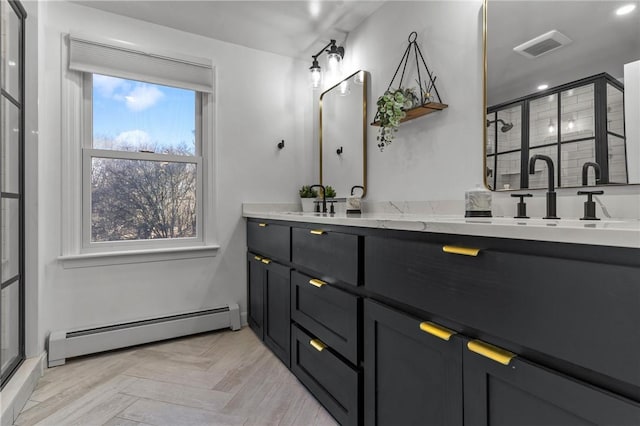 bathroom with double vanity, visible vents, a shower stall, a baseboard heating unit, and a sink