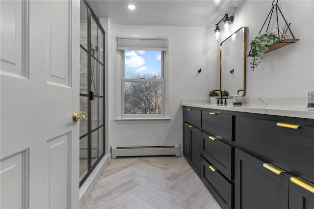 bathroom with a stall shower, vanity, baseboard heating, and recessed lighting