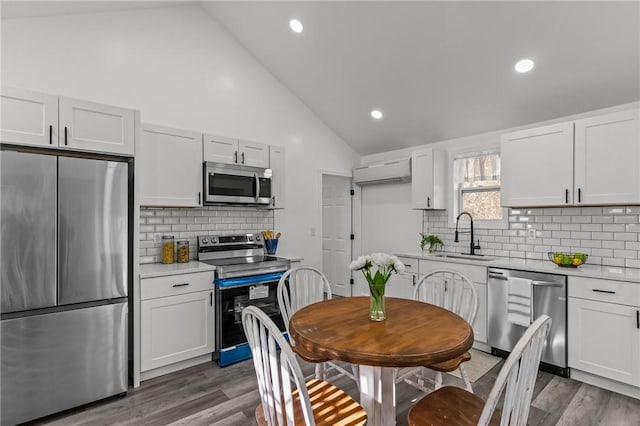 kitchen featuring stainless steel appliances, light countertops, a sink, and white cabinetry