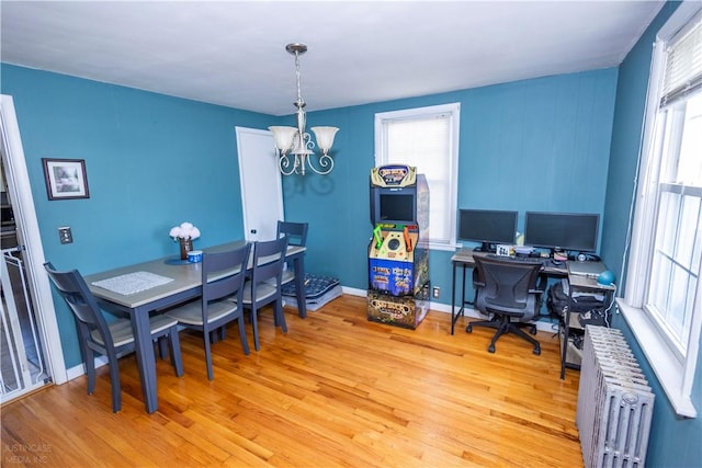 office space with radiator, baseboards, a notable chandelier, and light wood finished floors