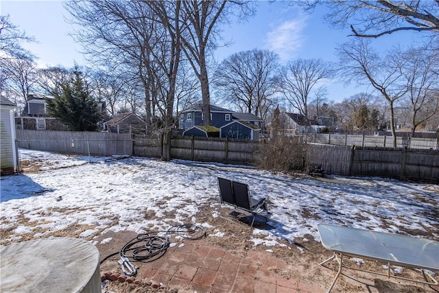 snowy yard featuring a fenced backyard