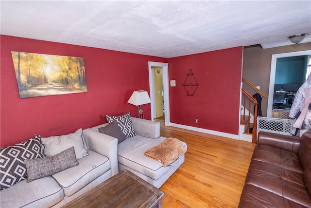 living room featuring stairway, wood finished floors, and baseboards