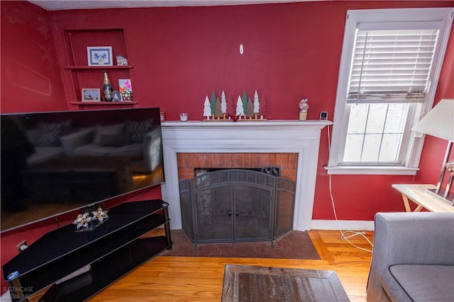 living room with a fireplace and wood finished floors