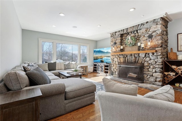 living room featuring a fireplace, wood finished floors, and recessed lighting