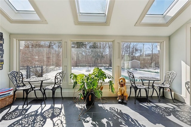 sunroom featuring lofted ceiling with skylight