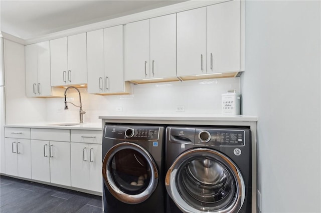 washroom with a sink, cabinet space, and washer and dryer