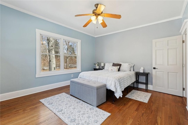 bedroom with crown molding, baseboards, ceiling fan, and wood finished floors