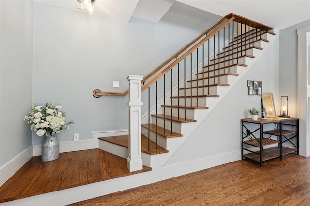 stairway featuring baseboards and wood finished floors