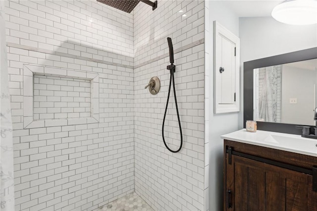 full bath with tiled shower and vanity