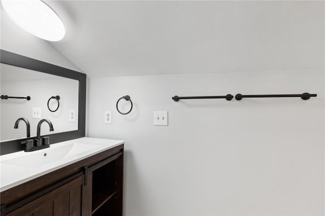 bathroom with lofted ceiling and vanity