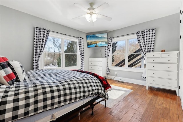 bedroom with ceiling fan, baseboards, and hardwood / wood-style floors