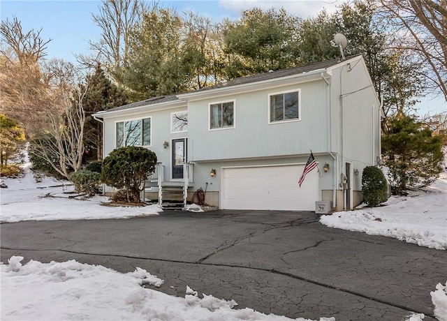 raised ranch with a garage and aphalt driveway