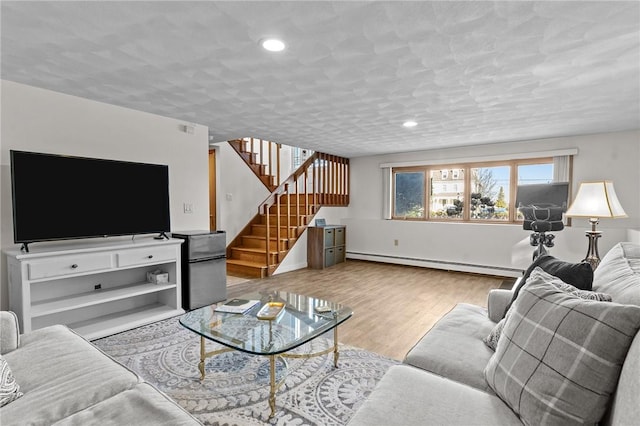 living area featuring recessed lighting, stairway, a baseboard heating unit, a textured ceiling, and wood finished floors